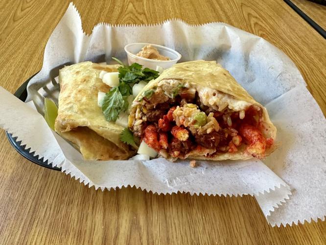 Ian Froeb’s St. Louis musteats a giant pork sandwich, a Cheetos