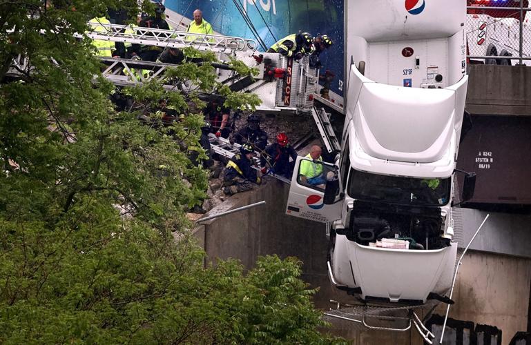 Truck driver rescued from crash that left him hanging of bridge