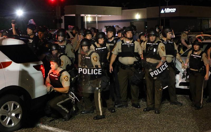 Police take cover when gunfire erupts on West Florissant Avenue