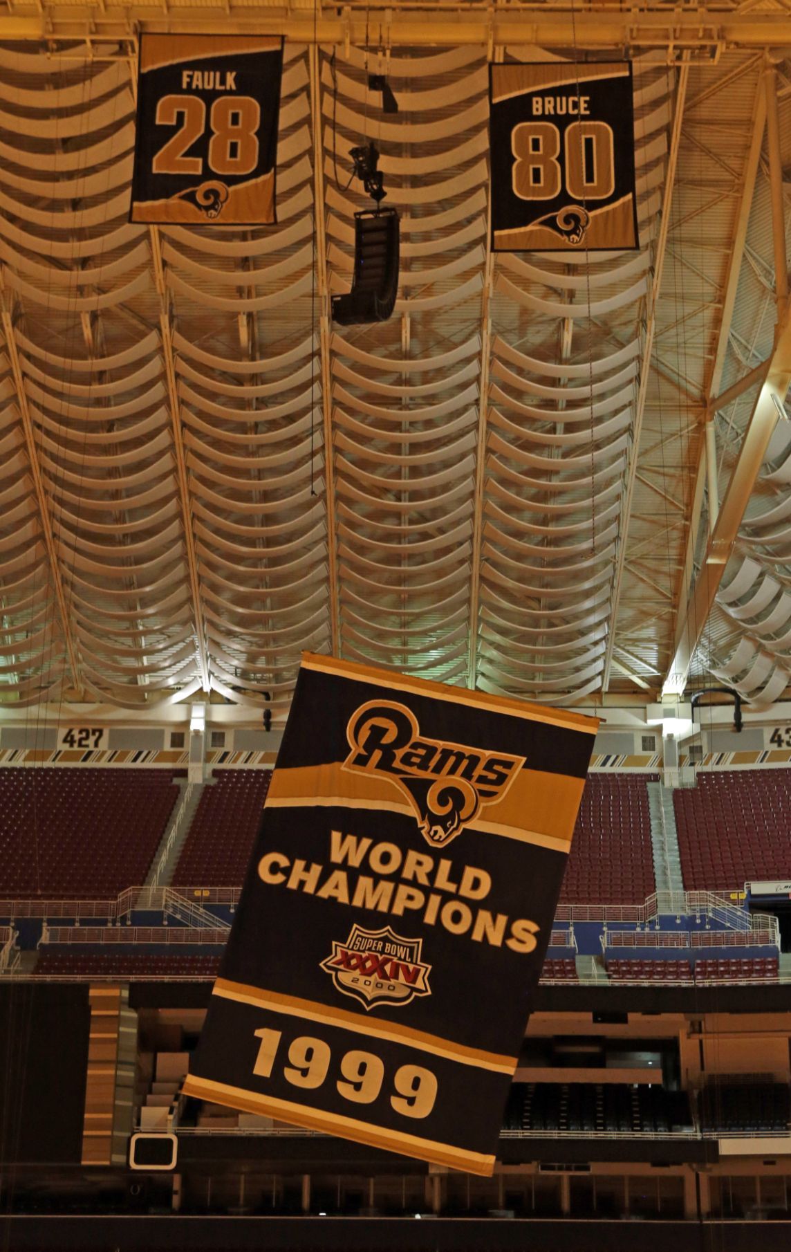 Decoraters wait for the St. Louis Rams Super Bowl banner to lower from the  rafters of the Edward Jones Dome in St. Louis on January 14, 2016. Signage  is being removed from