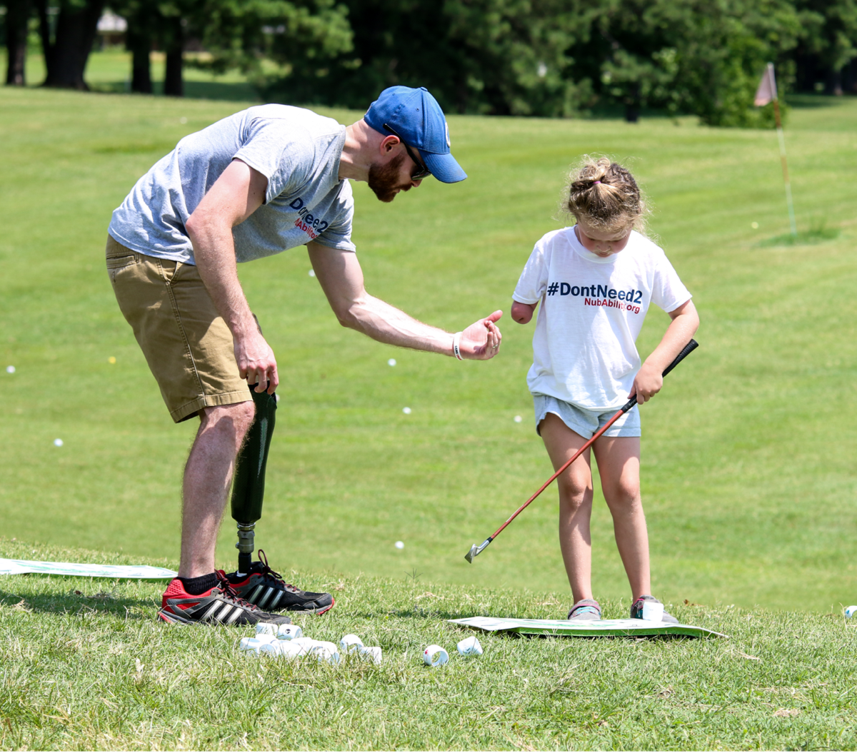 Limb-different coach and child play golf