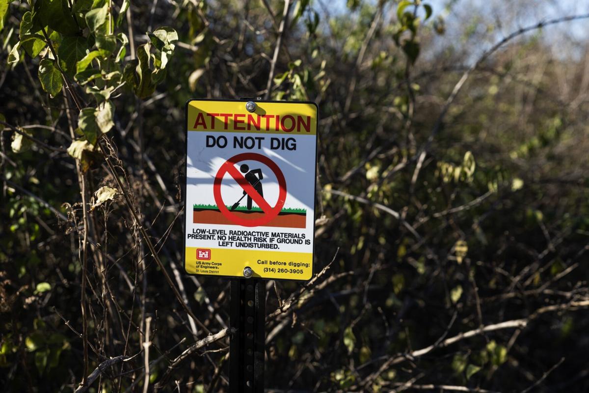 Contractors with the Army Corps of Engineers install signage along Coldwater Creek
