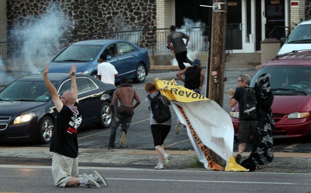 People scatter as officers fire tear gas in Ferguson