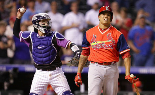 St. Louis Cardinals catcher Yadier Molina, left, celebrates with relief  pitcher Seung-Hwan Oh after he retired the Colorado Rockies' Tony Wolters  for the final out in the ninth inning of a baseball
