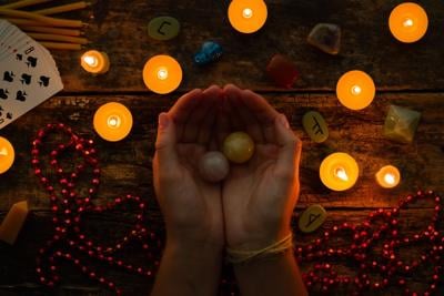 fortuneteller holds crystal balls for divination