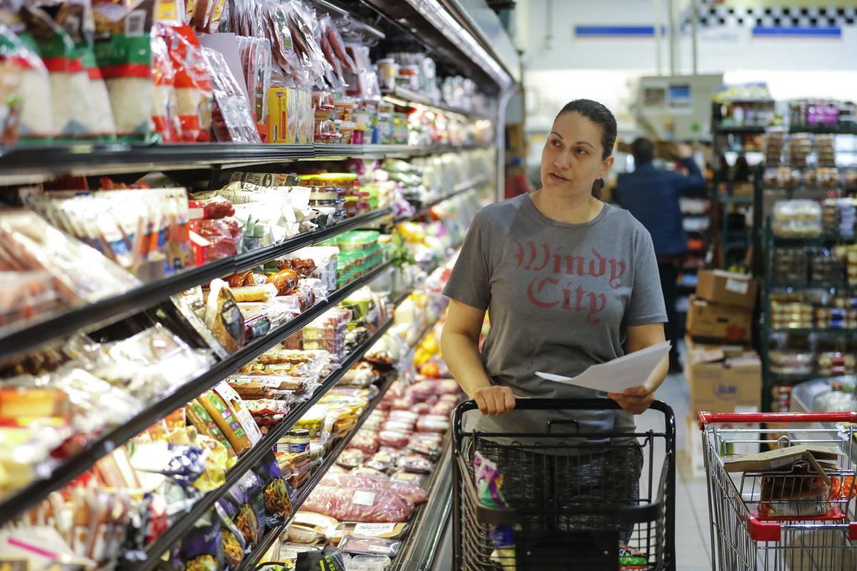 Elba Nunez, who works at Foodsmart Urban Market in Chicago, does grocery shopping for an online order at the store on Tuesday, March 24, 2020.