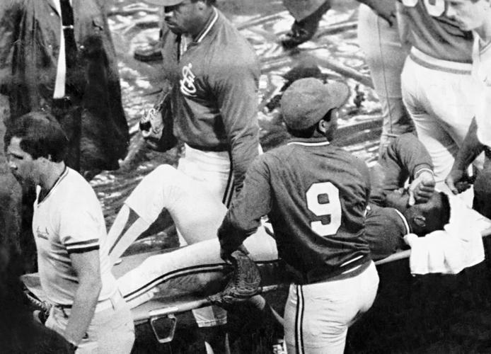 Vince Coleman of the St. Louis Cardinals writhes in pain after a