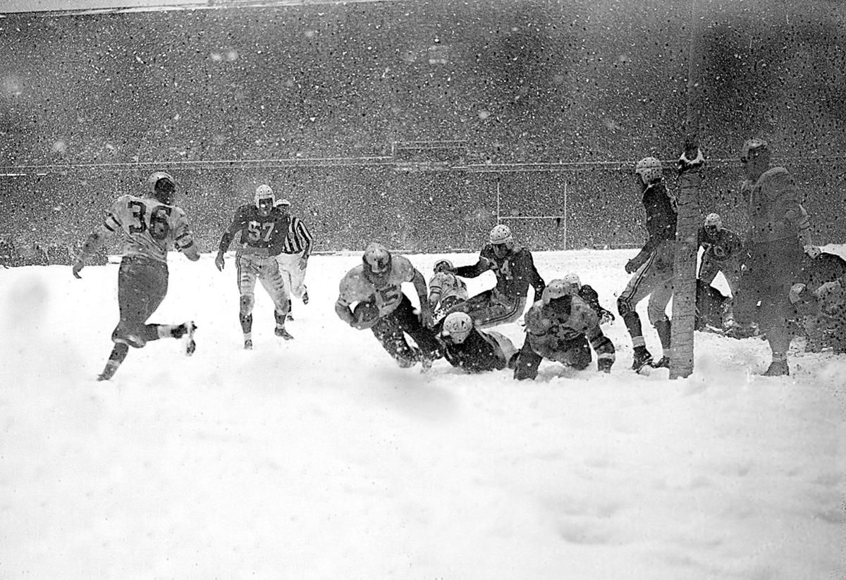 FILE - This Jan. 18, 1947, file photo shows Chicago Bears owner and coach  George Halas, left, watching as Bob Fenimore signs a contract with the Bears.  Halas left the Bears in