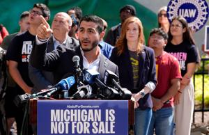 Abdul El-Sayed, the Democratic nomination for U.S. Senate, points up talking about how he used to work at a building near the