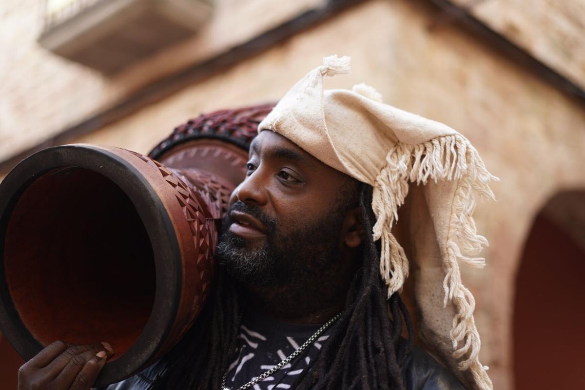 Djembefola Weedie Braimah holding his instrument