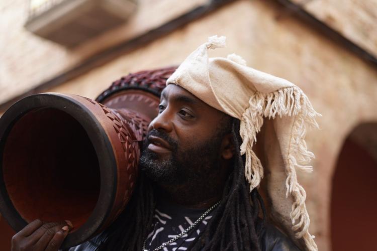 Djembefola Weedie Braimah holding his instrument