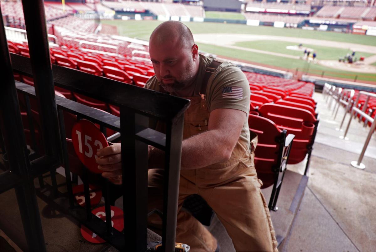 Workers install pitch clocks at Busch Stadium