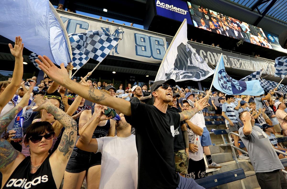 A fan holds up a scarf towards the Sporting Kansas City players