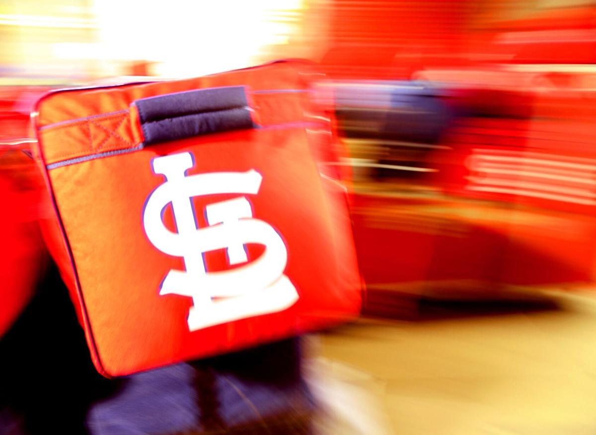 St. Louis Cardinals mascot Fredbird helps carry baggage from the