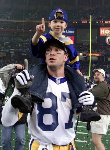 Former St. Louis Rams Isaac Bruce holds the Super Bowl trophy