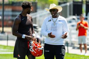 Deion Sanders spends time with his son, Cleveland Browns quarterback Shedeur Sanders (2) at the conclusion of the second day of