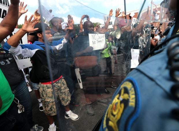 Protester in Ferguson holds "no justice, no peace" sign