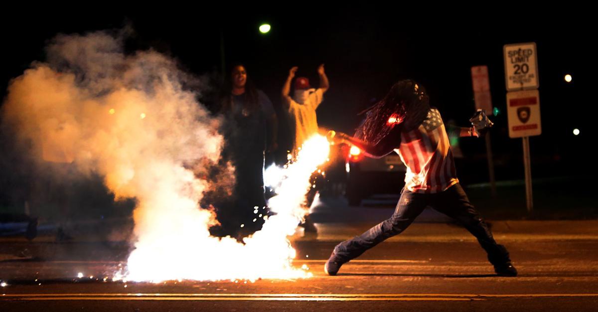 Protester throws tear gas container during Ferguson protests