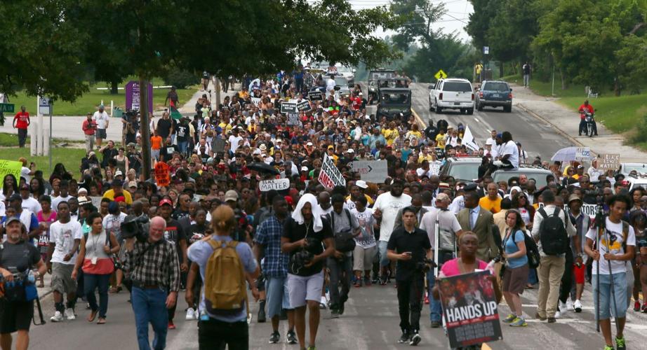 People gather on the anniversary of the fatal police shooting of Michael Brown