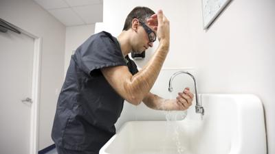 Dr. Keith Reisinger-Kindle scrubs in to a surgical abortion at Equity Clinic on May 21, 2023, in Champaign. (Shanna Madison/Chicago Tribune)