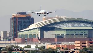 United Airlines flight 1796 flies past Chase Field on approach to Phoenix Sky Harbor International Airport on Nov. 7, 2025, during the government shutdown.