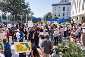 Activists gather outside the North Portico at the Florida Capitol to protest the proposed redistricting map Tuesday, April 28,