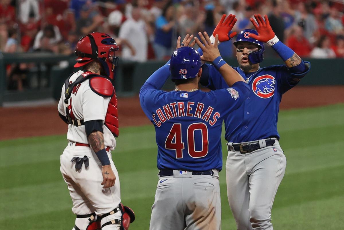 Javier Baez high-fives Willson Contreras after hitting a homer in a Cardinals vs. Chicago Cubs game.