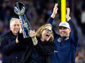 Seattle Seahawks chairman Jody Allen celebrates with the Vince Lombardi trophy on the podium after Seattle defeated the New England Patriots in Super Bowl LX at Levi's Stadium in Santa Clara, California.
