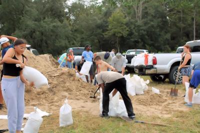 At sandpile, people fill bags to protect their homes