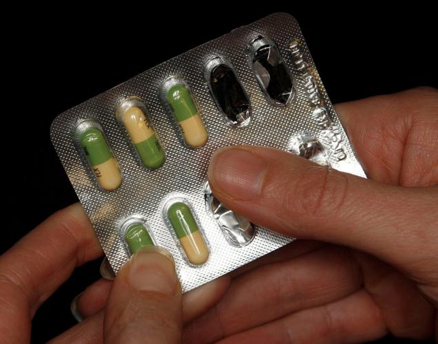 FILE PHOTO: A woman holds a packet of an antidepressant drug in Leicester