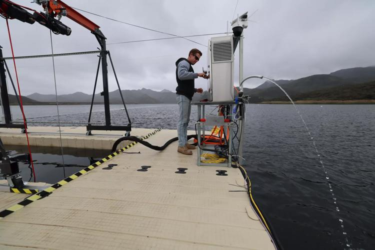 Mark Golay, director of engineering projects at OceanWell, monitors filtered water coming from a pump as the company tests a prototype of its desalination pod at Las Virgenes Reservoir.