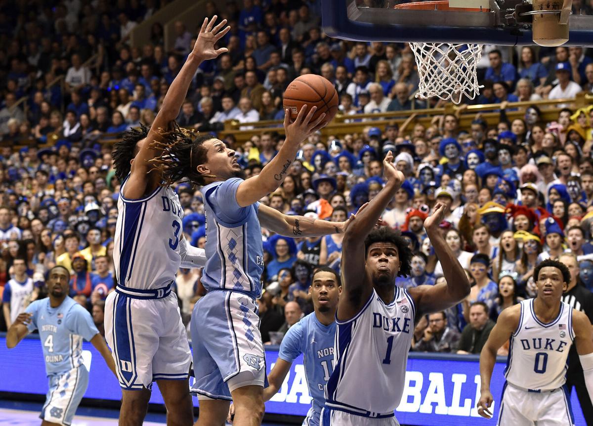 In this file image, Cole Anthony #2 of the North Carolina Tar Heels drives between Tre Jones #3 and Vernon Carey Jr. #1 of the Duke Blue Devils during the second half of their game at Cameron Indoor Stadium on March 7, 2020 in Durham, North Carolina.