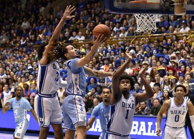 In this file image, Cole Anthony #2 of the North Carolina Tar Heels drives between Tre Jones #3 and Vernon Carey Jr. #1 of the Duke Blue Devils during the second half of their game at Cameron Indoor Stadium on March 7, 2020 in Durham, North Carolina.