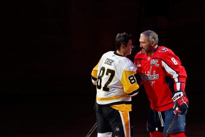 Pittsburgh Penguins center Sidney Crosby (87) and Washington Capitals left wing Alex Ovechkin (8) shake hands after a puck drop ceremony.