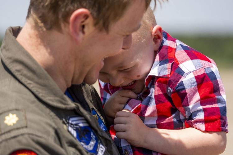 Jack Giesler, 3, laughs while being held by his father Lt. Commander Jeff Giesler. The Pukin Dogs of Strike Fighter Squadron 143 returned home from Carrier Strike Group 10 to Naval Air Station Oceana in Virginia Beach, Virginia, on April 21, 2023.
