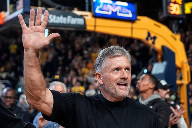 Michigan football head coach Kyle Whittingham waves at the crowd as he is being introduced on the floor during the men's basketball game between Michigan and USC at Crisler Center in Ann Arbor on Jan. 2, 2026.
