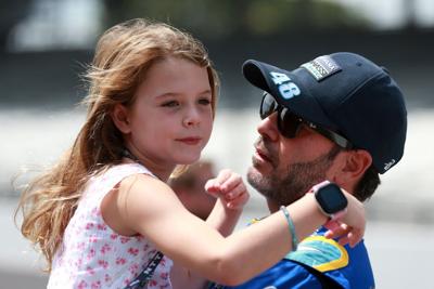 Jimmie Johnson, driver of the #48 Carvana Chip Ganassi Racing Honda, holds his daughter, Lydia Norriss on the grid prior to the NTT IndyCar Series Big Machine Spiked Coolers Grand Prix at Indianapolis Motor Speedway on Aug. 14, 2021 in Indianapolis.