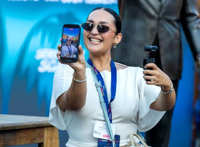 Content creator Isabella Morello Rodriguez records a video on her phone and DJI Osmo camera during a Disney influencer somos magic event.