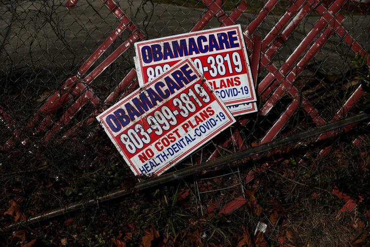 FILE PHOTO: Signs for former Obamacare health insurance plans lay next to a fence in Columbia, South Carolina