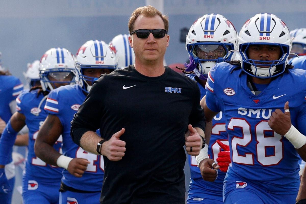 SMU head coach Rhett Lashlee and players run onto the field before an NCAA college football game against Louisville at Gerald J. Ford Stadium, Saturday, Nov. 22, 2025, in University Park, Texas.