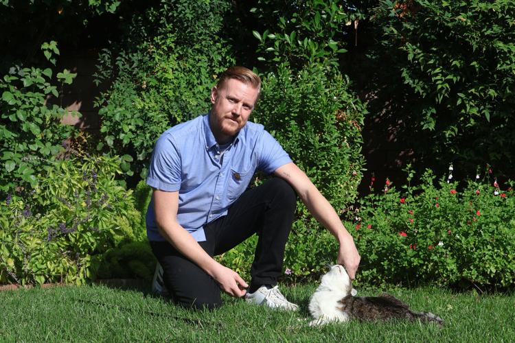 Kris Edwards and his cat, Rex, in the garden of the home he bought with his wife, Erika“ Tilly” Edwards, only four days before her death.