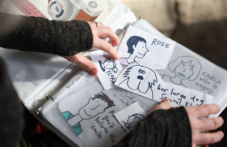 Sara Levine sifts through a box of drawings from 2012 that she created in the early stages of writing her novel“ The Hinge” at her home on Jan. 9, 2026, in Evanston.