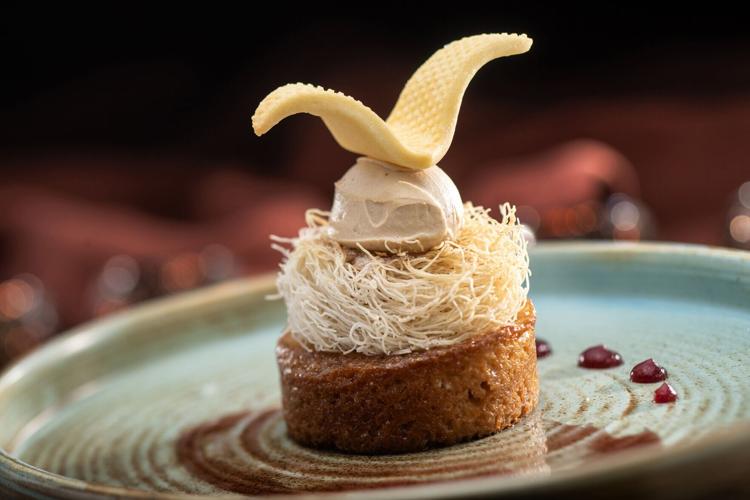 Sweet, spongy Malva Pudding, a South African dessert, features cake infused with Amarula, a regional liqueur, caramel-sea salt gelato, crisp kataifi, chocolate garnish and Shiraz gelée.