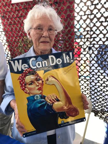 Jennifer McMullen holds a "Rosie the Riveter" poster at an air show in 2018. She was an 18-year-old riveter during World War II.