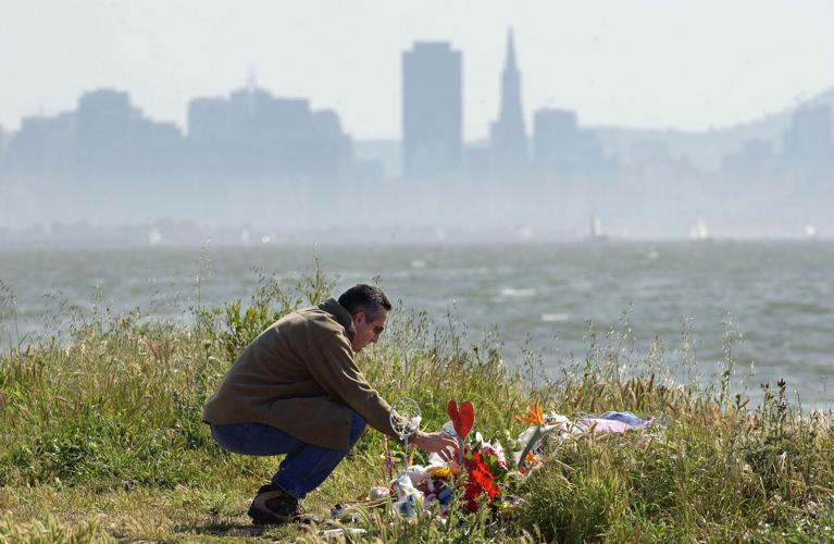 Michael Accurso of El Sobrante, California, pours water on some flowers at a memorial that includes flowers, candles and stuffed toys on April 19, 2003, in Richmond, California. The makeshift memorial is the location where the body of Laci Peterson and ...