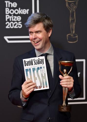 Booker Prize 2025 winner David Szalay, author of "Flesh" celebrates with the award and book during The Booker Prize 2025 Ceremony at Old Billingsgate on Nov. 10, 2025, in London.