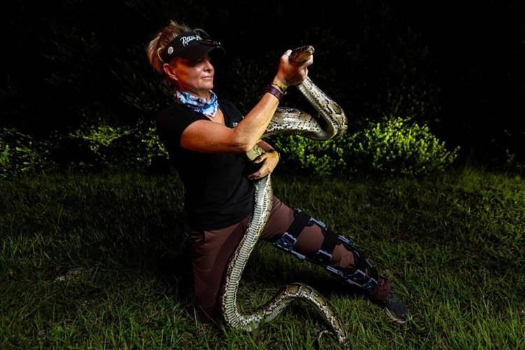 Python Huntress Amy Siewe holds an invasive 10- foot Burmese Python, originally caught by her colleague Harold Antonio Rondon-Mena, during a hunting trip down Tamiami Trail on Sept. 5, 2024, in Miami.