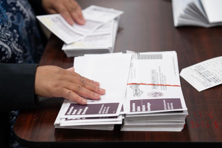 Jackie Jones works with Jon Bruning to process absentee ballots, verifying the address with the original request, at Central Count on Election Day, April 7, 2026 in Milwaukee, Wisconsin.
