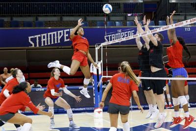 SMU volleyball player Natalia Newsome, middle, jumps to spike the ball during a practice at SMU's Moody Coliseum on Oct. 14, 2025, in University Park, Texas.