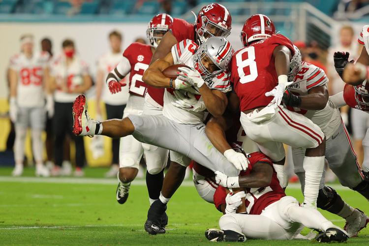 Christian Barmore #58 of the Alabama Crimson Tide tackles Master Teague III #33 of the Ohio State Buckeyes during the second quarter of the College Football Playoff National Championship game at Hard Rock Stadium on Jan. 11, 2021 in Miami Gardens, Florida.